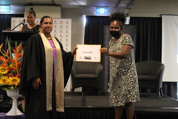 Amelia Raka being presented with her certificate