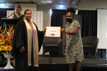 Amelia Raka being presented with her certificate